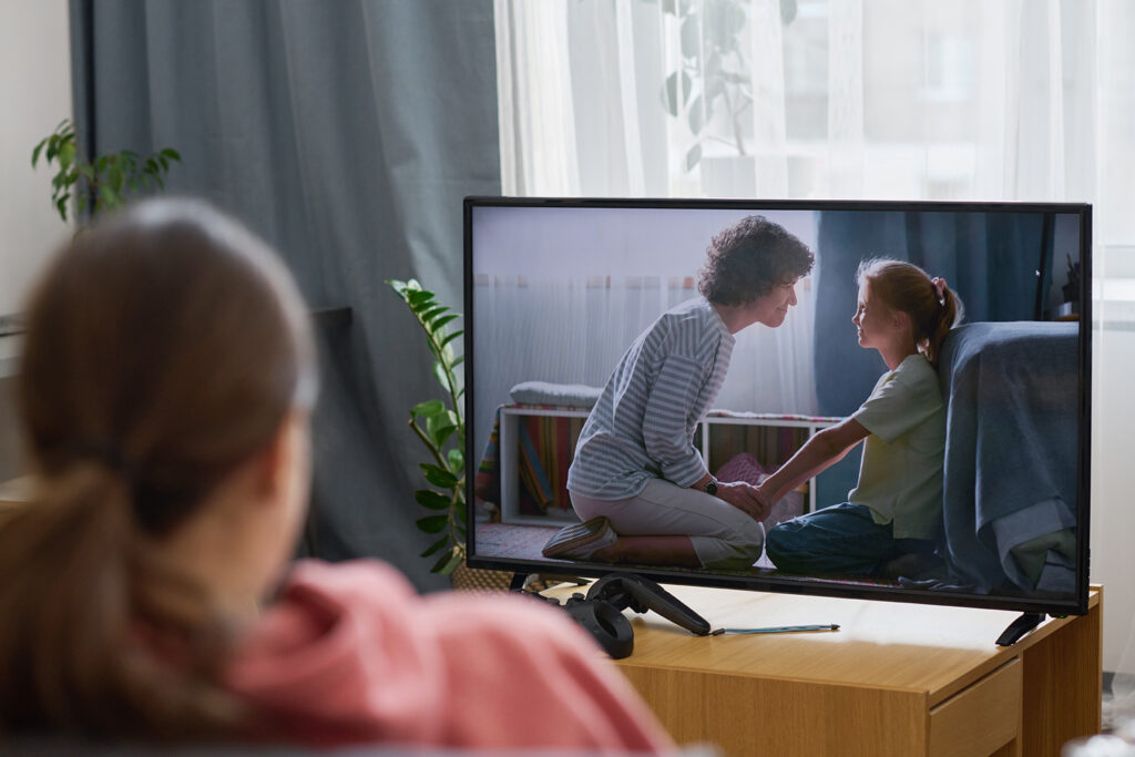 Frau, die Fernsehen auf ihrer Couch schaut mit installierten TV-Empfang von Elektro Kaufmann.